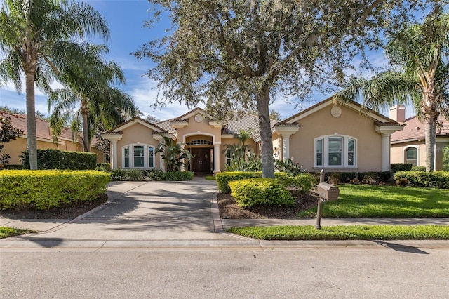 mediterranean / spanish-style home with a front lawn