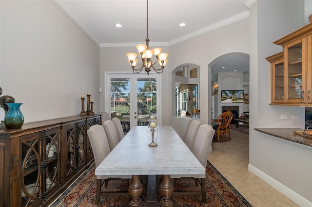 dining area featuring french doors, an inviting chandelier, tile patterned floors, and crown molding