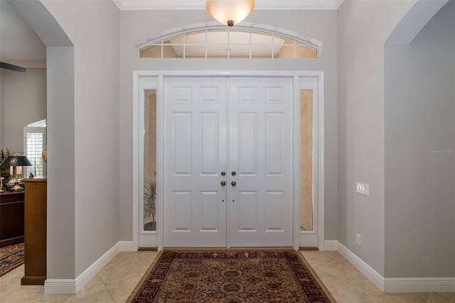 tiled foyer entrance with crown molding