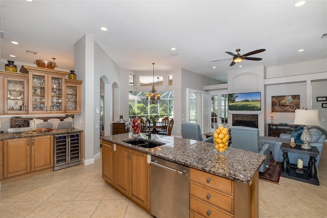 kitchen featuring dishwasher, dark stone counters, a center island with sink, sink, and wine cooler