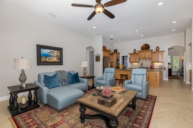 living room with ceiling fan, sink, and light tile patterned flooring