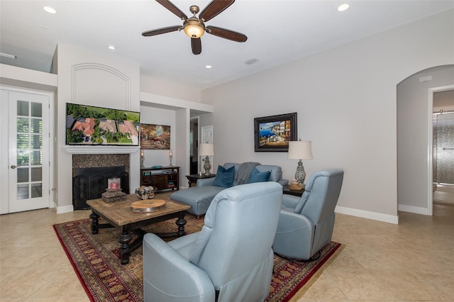 living room featuring ceiling fan and a fireplace