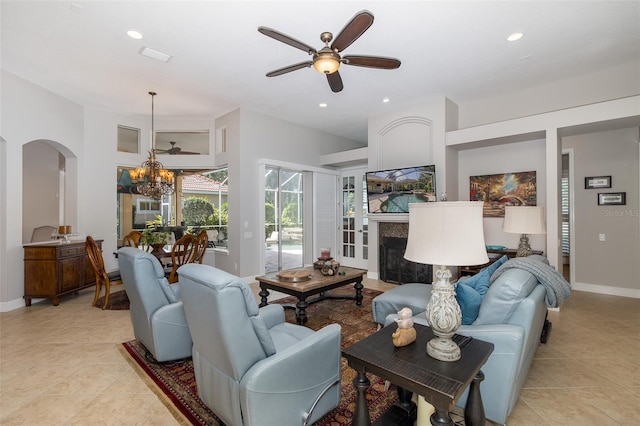 living room with light tile patterned flooring and ceiling fan with notable chandelier