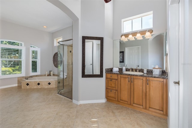 bathroom with vanity, tile patterned flooring, and plus walk in shower