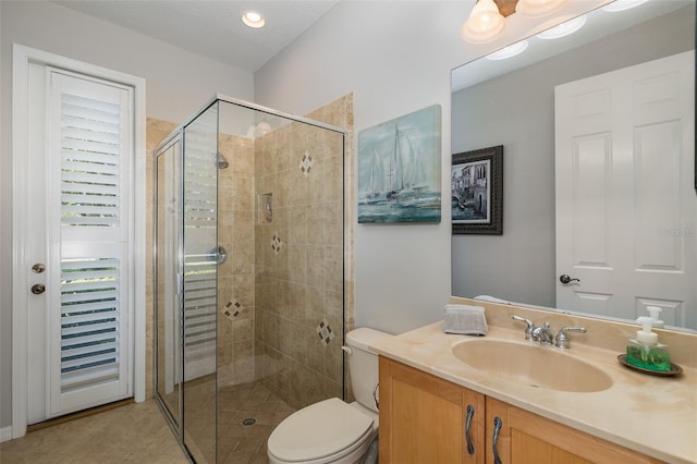 bathroom featuring tile patterned floors, vanity, a textured ceiling, toilet, and a shower with shower door