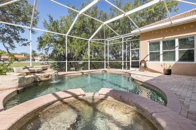 view of swimming pool featuring pool water feature, a lanai, a patio area, and an in ground hot tub