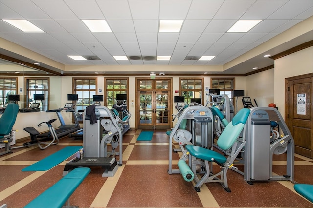 gym with a paneled ceiling and french doors