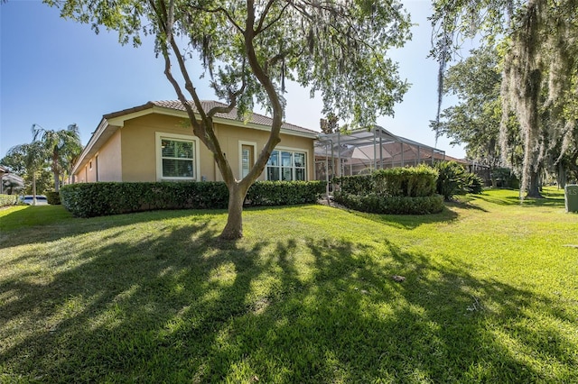 back of property with a lanai and a yard