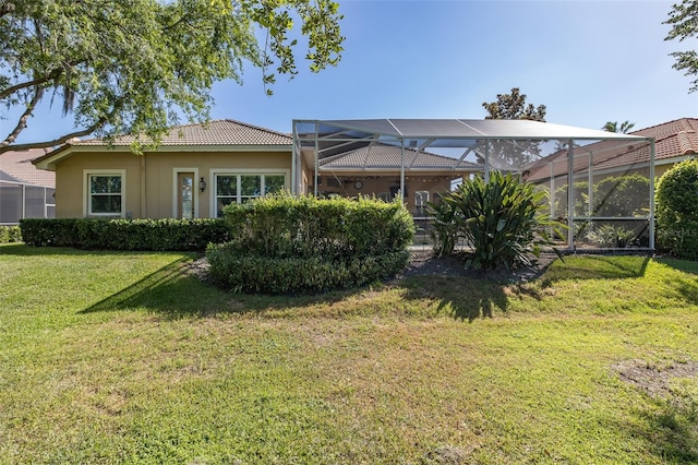 rear view of property with a lawn and a lanai