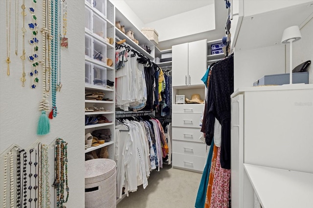 walk in closet with light colored carpet