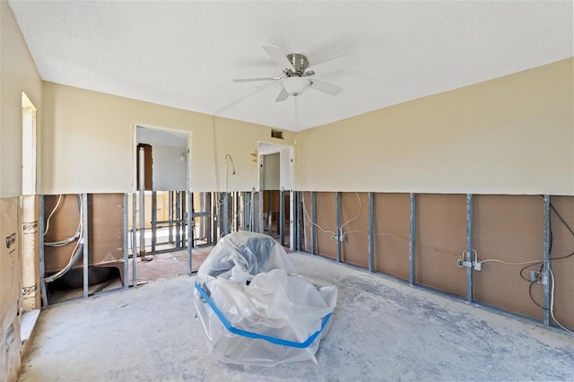 unfurnished room with ceiling fan and a textured ceiling