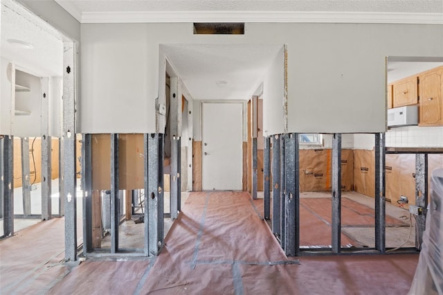 corridor featuring ornamental molding and a textured ceiling