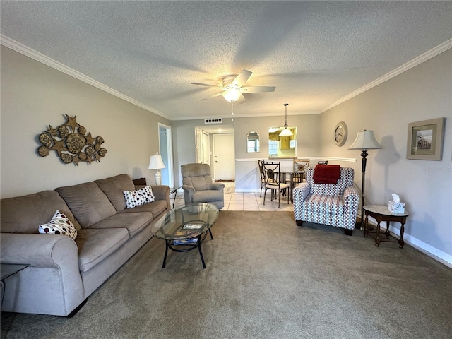 living room with ceiling fan, ornamental molding, a textured ceiling, and carpet flooring