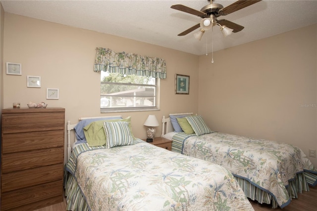 bedroom with ceiling fan and a textured ceiling