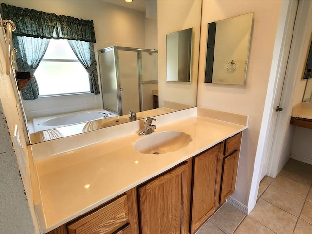 bathroom with independent shower and bath, vanity with extensive cabinet space, and tile floors