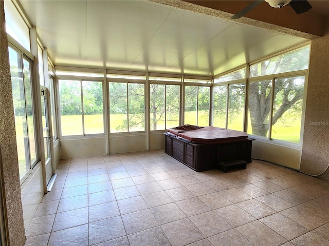 unfurnished sunroom featuring a wealth of natural light and ceiling fan