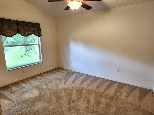 carpeted spare room with ceiling fan and lofted ceiling