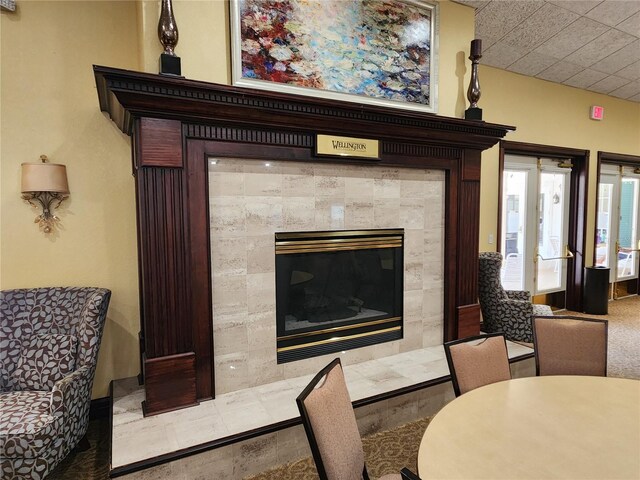 living room featuring a tile fireplace and tile floors