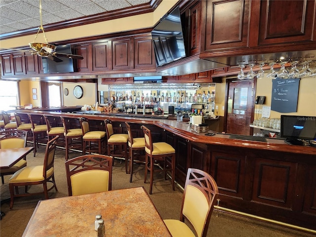 bar featuring ceiling fan and crown molding