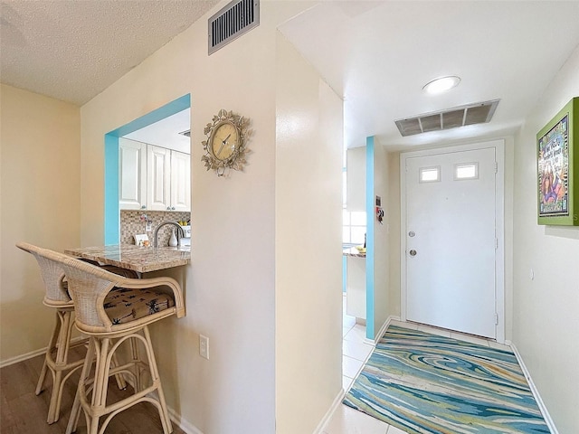 tiled entrance foyer featuring a textured ceiling