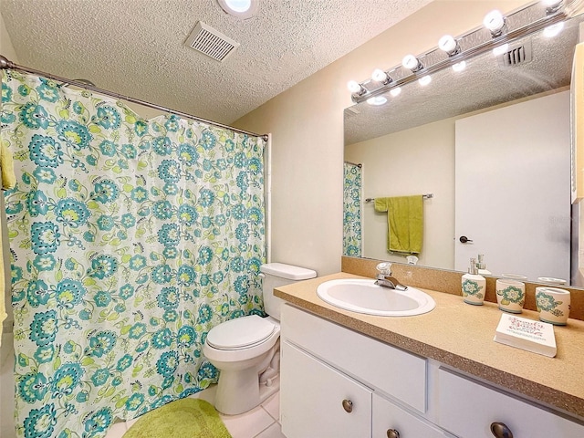 bathroom featuring vanity with extensive cabinet space, toilet, tile floors, and a textured ceiling