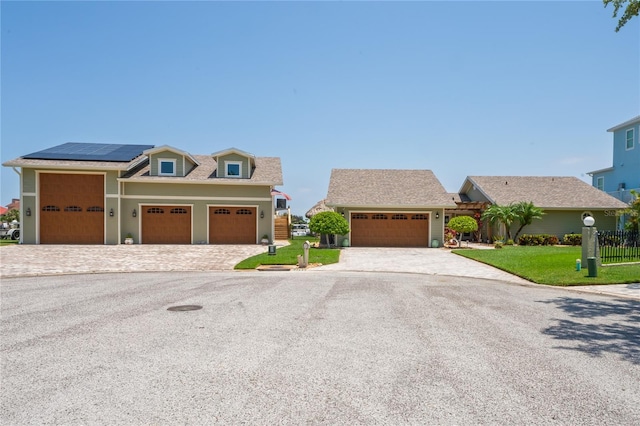 view of front of home featuring a front lawn and solar panels