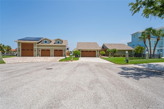 view of front of home featuring a front lawn, a garage, and solar panels