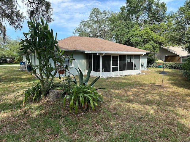 back of property with a lawn and a sunroom