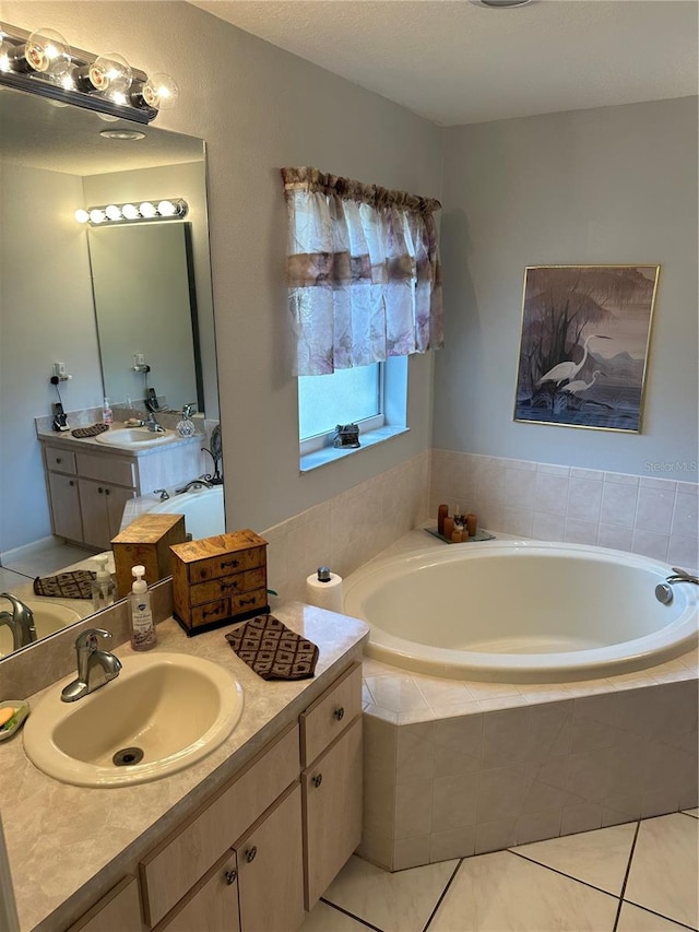 bathroom featuring tile patterned floors, vanity, and tiled bath