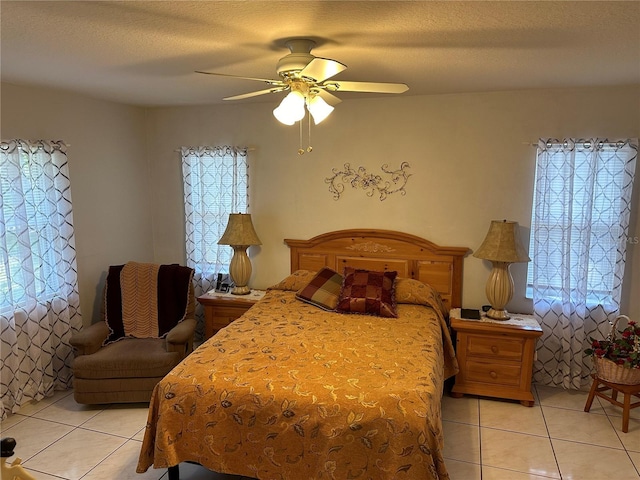 tiled bedroom featuring ceiling fan and a textured ceiling