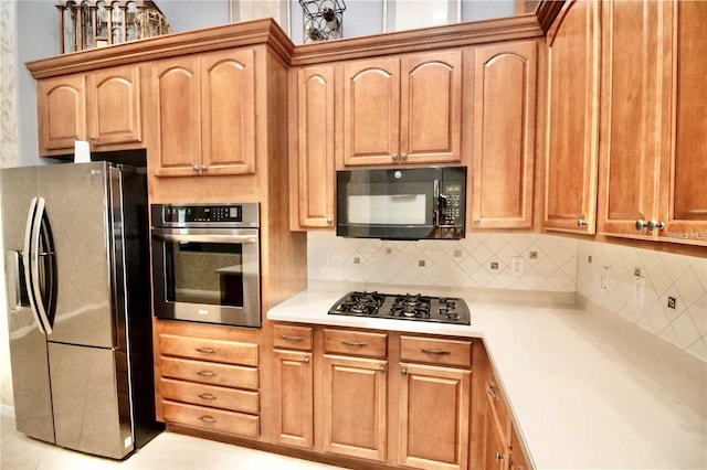 kitchen featuring stainless steel appliances, tasteful backsplash, and light tile flooring