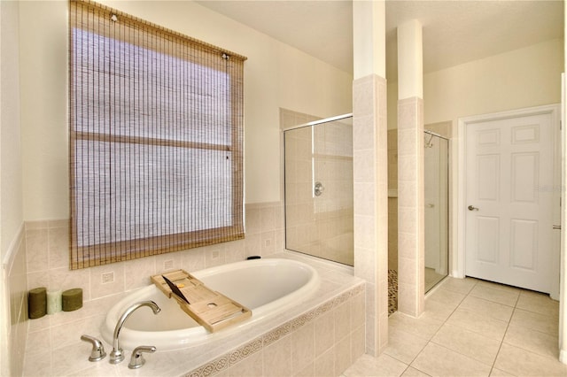 bathroom featuring shower with separate bathtub and tile floors