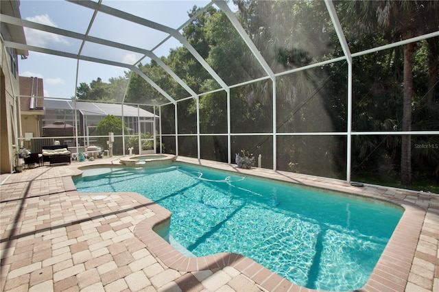 view of swimming pool featuring a patio area, glass enclosure, and an in ground hot tub