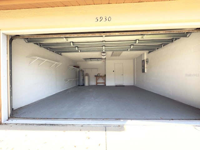 garage featuring a garage door opener, electric panel, and electric water heater