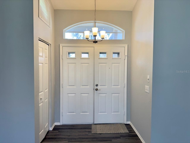 foyer entrance featuring dark hardwood / wood-style floors and a chandelier