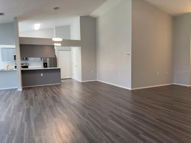 unfurnished living room with dark hardwood / wood-style flooring and high vaulted ceiling