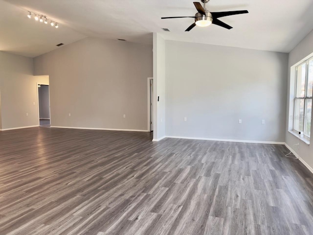 empty room with vaulted ceiling, dark hardwood / wood-style floors, and ceiling fan