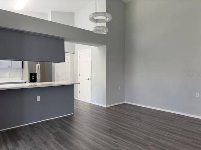 kitchen with stainless steel refrigerator with ice dispenser, high vaulted ceiling, kitchen peninsula, and dark wood-type flooring