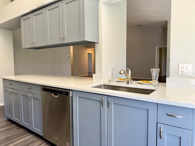 kitchen featuring stainless steel dishwasher, dark hardwood / wood-style flooring, gray cabinets, and sink