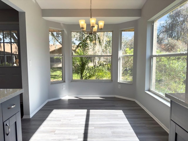 unfurnished dining area with dark wood-type flooring and an inviting chandelier