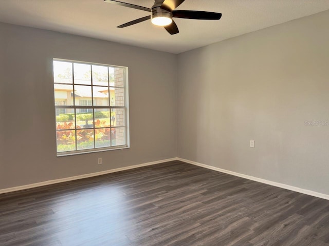 unfurnished room featuring dark wood-type flooring and ceiling fan