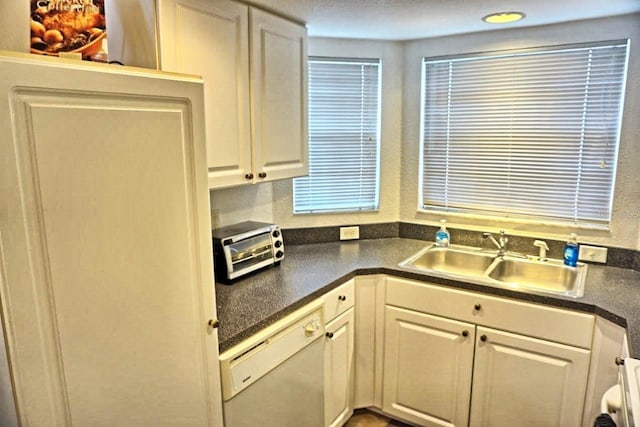 kitchen with sink, white cabinets, and white dishwasher