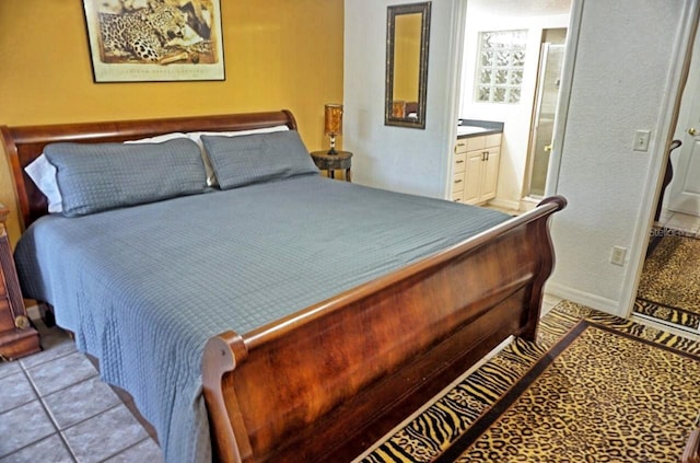 bedroom with tile floors and connected bathroom