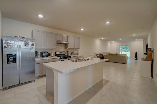 kitchen with an island with sink, gray cabinets, appliances with stainless steel finishes, sink, and light tile floors