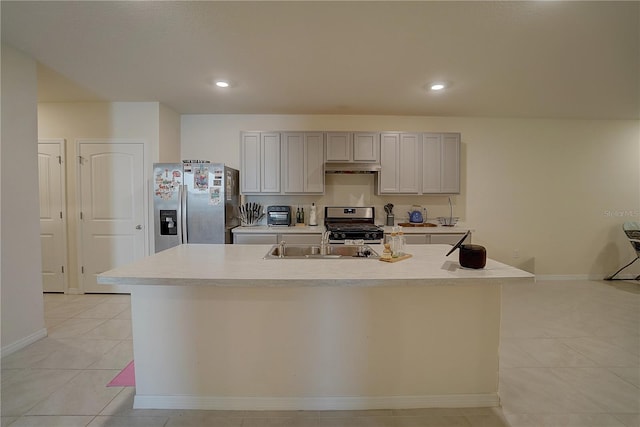 kitchen with light tile flooring, a center island with sink, gray cabinetry, appliances with stainless steel finishes, and sink