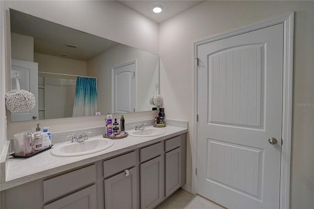 bathroom featuring tile flooring, oversized vanity, and double sink