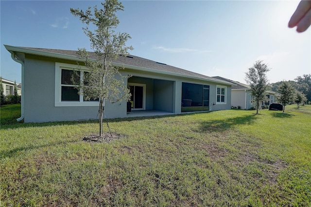 rear view of house featuring a yard