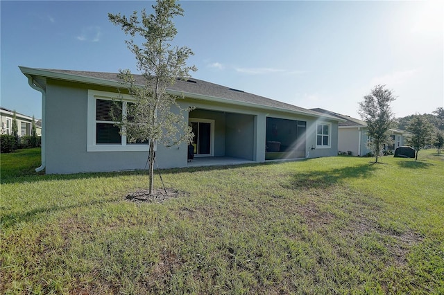 rear view of house featuring a yard