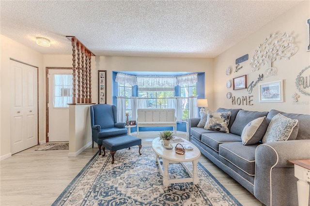 living room featuring a textured ceiling and light wood-type flooring