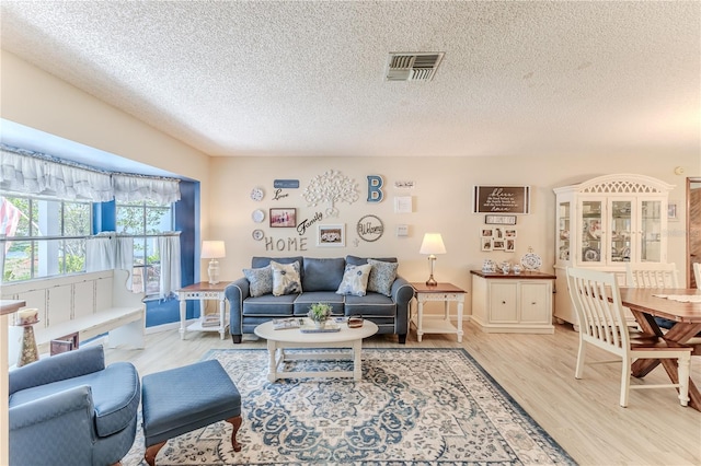 living room with light hardwood / wood-style floors and a textured ceiling